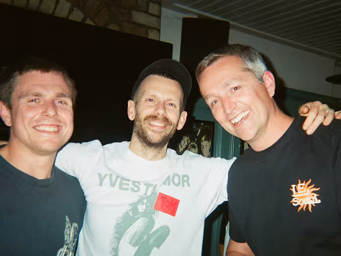 Three colleagues in smiling to camera